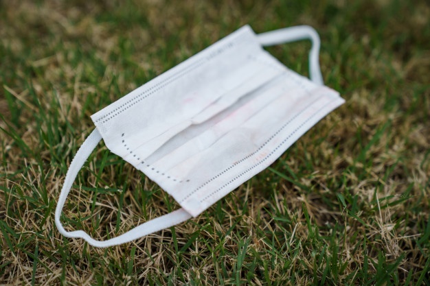 mascara-quirurgica-cara-sucia-usada-caida-sobre-hierba_46370-1293